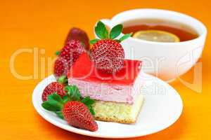 lemon tea, cake and strawberries lying on the orange fabric