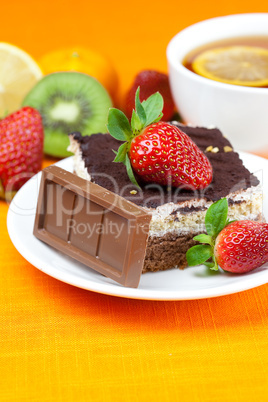 lemon tea,chocolate, kiwi,cake and strawberries lying on the ora