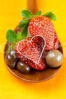 strawberry, hearts and chocolate candy in the wooden spoon of th