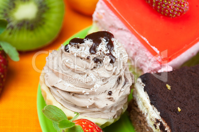 kiwi,cake and strawberries lying on the orange fabric