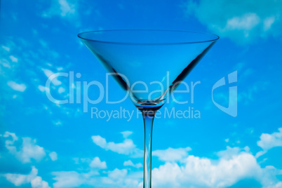 conceptually illuminated martini glass against the sky