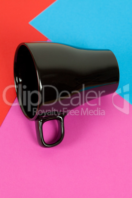 a black cup lying on colorful background