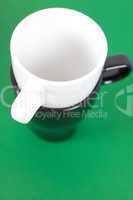 black and white cup standing on a green background