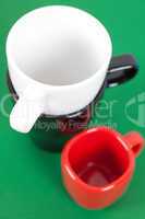 white, red and black cup standing on a green background