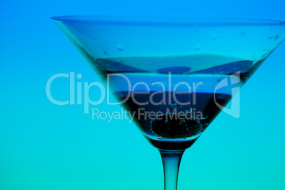 conceptually illuminated martini glass on gradient background