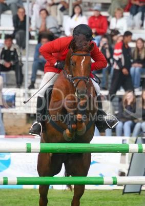 The jockey jumps through an obstacle