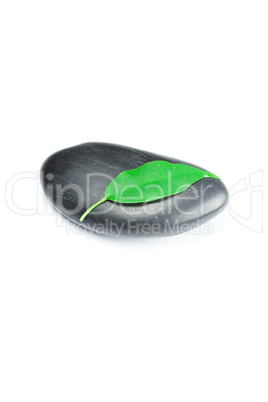 black spa stones   with green leaf and a drop of water isolated