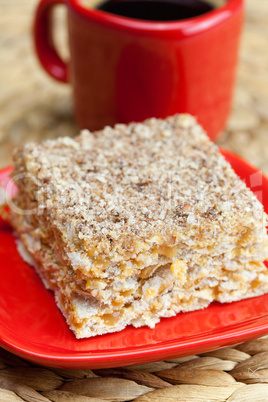 cake on a plate and a cup of coffee on a wicker mat