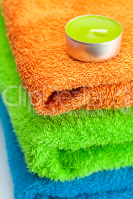 background of the three multi colored terry towels and candle