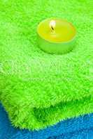 a burning candle lying on the towel