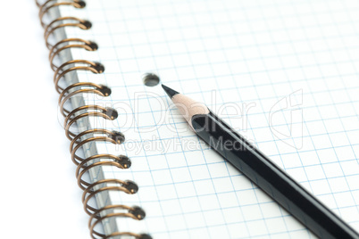 plaid notebook with a spiral  and pencil