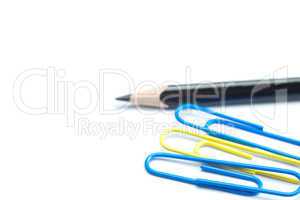 black pencil and colored paper clip isolated on white