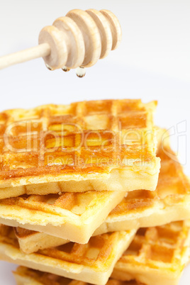 delicious Belgian waffles and stick to honey isolated on white