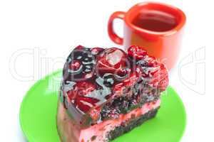 beautiful cake with berries on a plate and a cup of tea isolated
