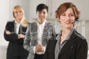 Pretty Red Haired Businesswoman with Headset and Colleagues