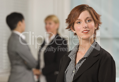 Pretty Red Haired Businesswoman with Colleagues Behind