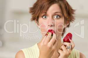 Pretty Wide-eyed Red Haired Woman Biting Strawberry