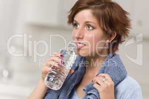Pretty Red Haired Woman with Towel Drinking From Water Bottle