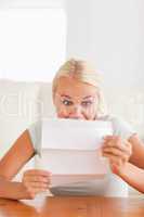 Woman looking at a letter in disbelief