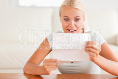 Woman looking at a letter in amazement