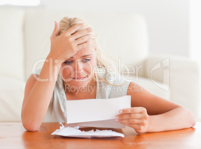 Blond woman in despair holding a letter