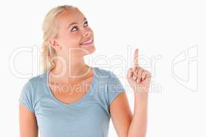 Smiling blond woman pointing at copyspace