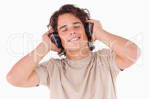 Smiling man with headphones having eyes closed