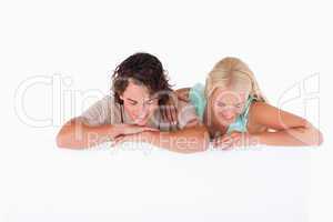 Cute smiling couple leaning on a whiteboard