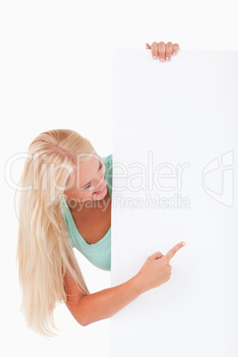 Blond-haired woman pointing at a whiteboard