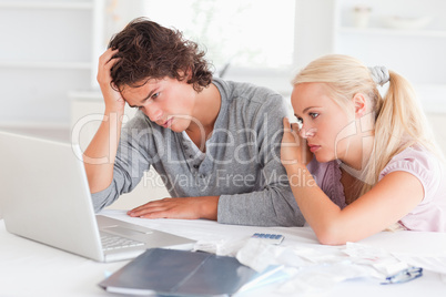 Upset couple with bills and a notebook