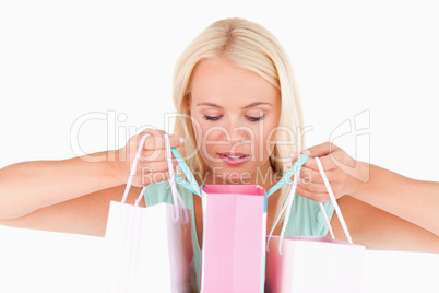 Joyful blond woman looking into her bags