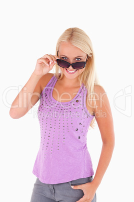 Charming woman peeking over her sunglasses