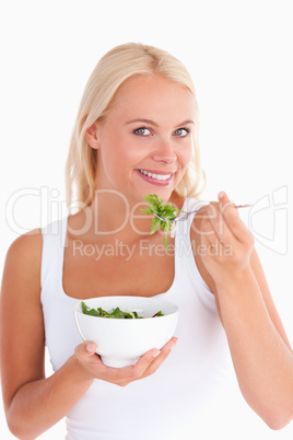 Smiling woman eating salad