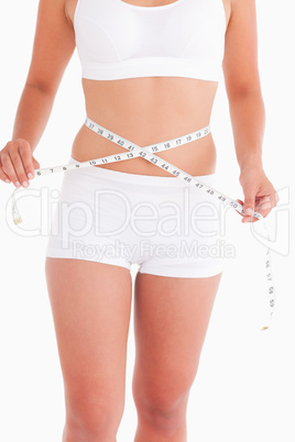 Young lady measuring her waist
