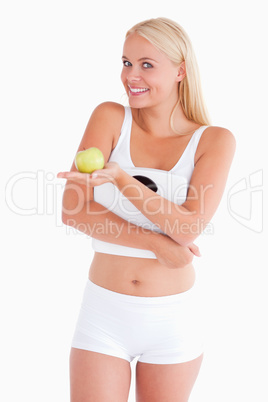 Young woman holding an apple and a scale