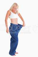 Smiling woman wearing to big jeans