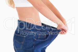 Woman wearing to big jeans