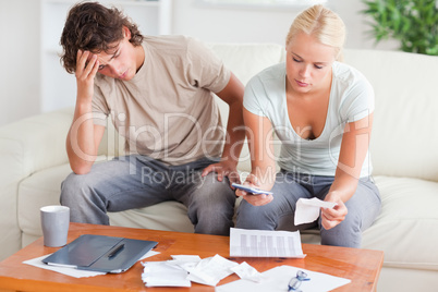 Stressed couple calculating their expenses