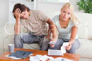 Worried couple calculating their expenses