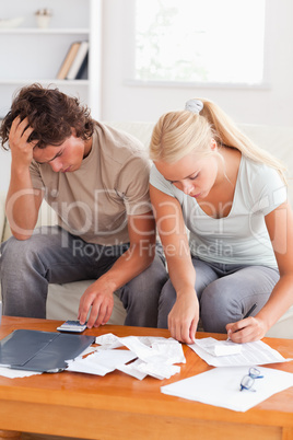 Despaired couple calculating their expenses