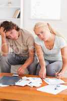 Despaired stressed couple calculating their expenses