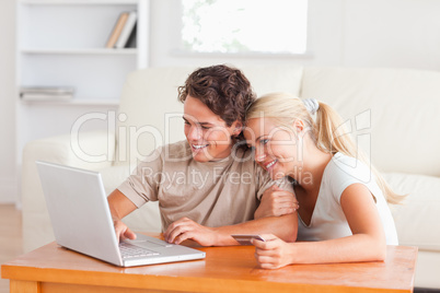 Cute couple with a laptop and a credit card