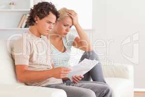 Unhappy couple holding an invoice