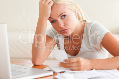 Worried woman doing accounts looking into the camera