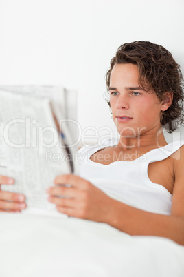 Portrait of a young man reading a newspaper