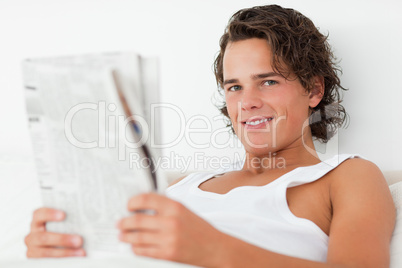 Close up of a young man holding a newspaper