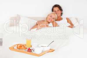 Couple smiling with the breakfast put on a tray