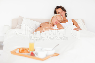 Sleeping couple with the breakfast put on a tray