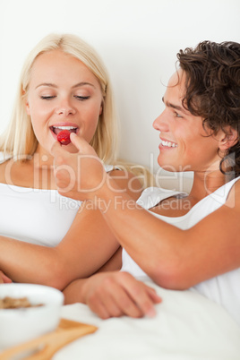 Portrait of a man giving a strawberry to his girlfriend