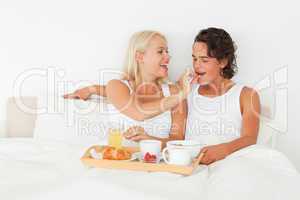 Woman giving a piece of croissant to her fiance